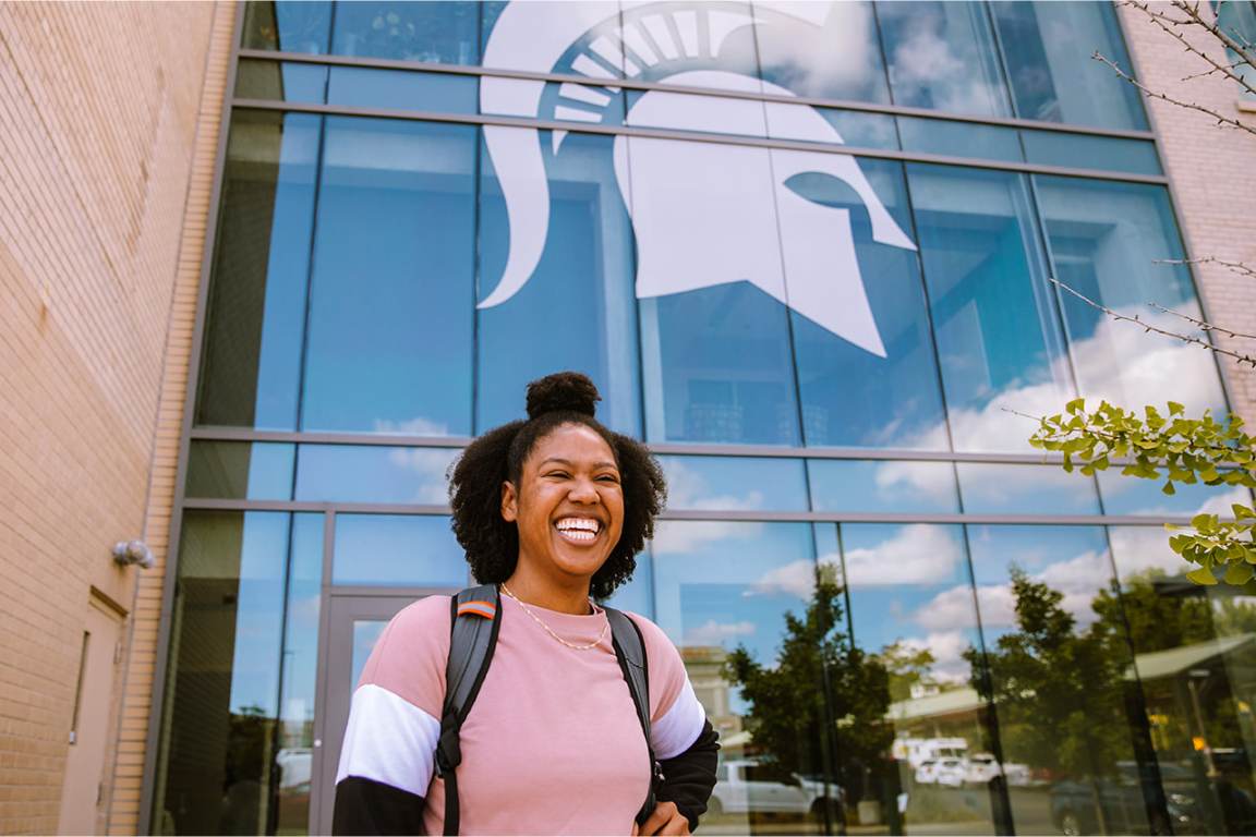 Person standing in front of Flint Journal Building