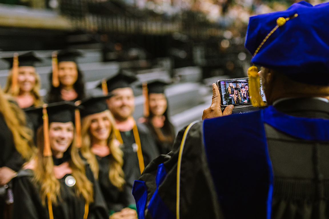 Someone taking a picture of students at graduation